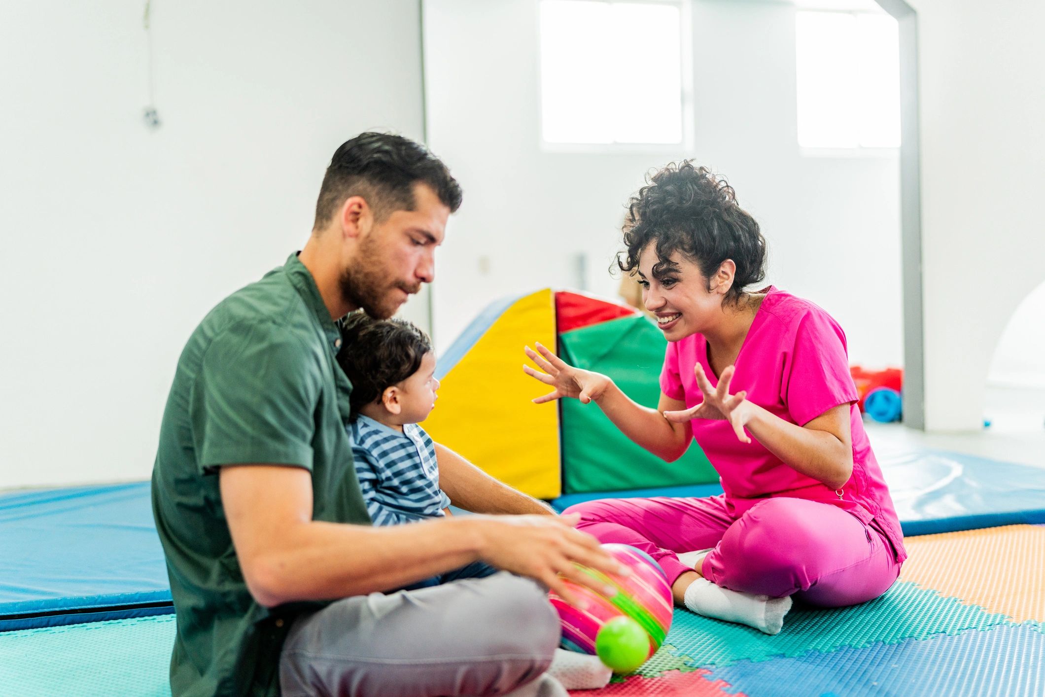 Parent and child speaking with a therapist at a clinic