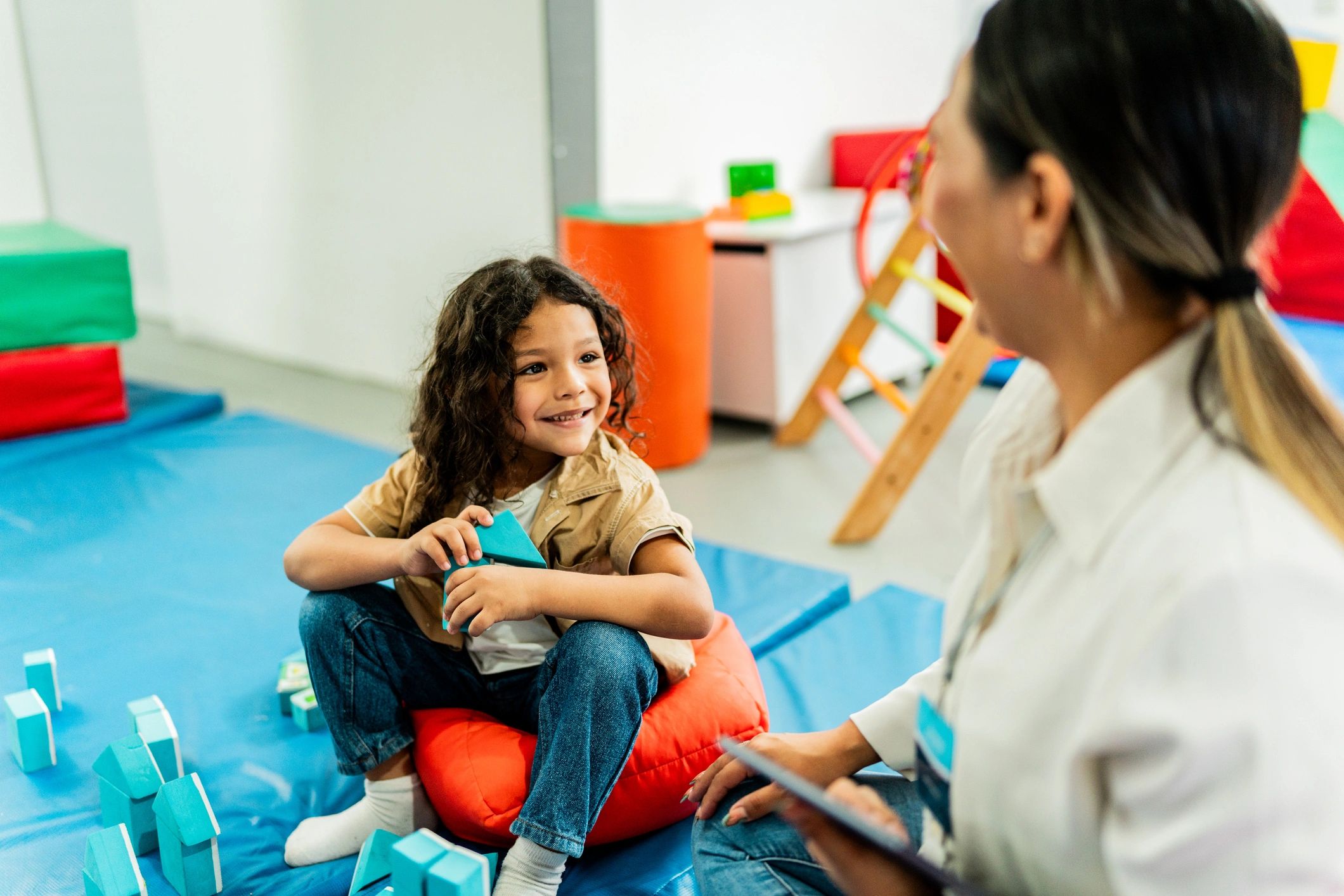 Therapist and child building blocks together during a pediatric therapy session