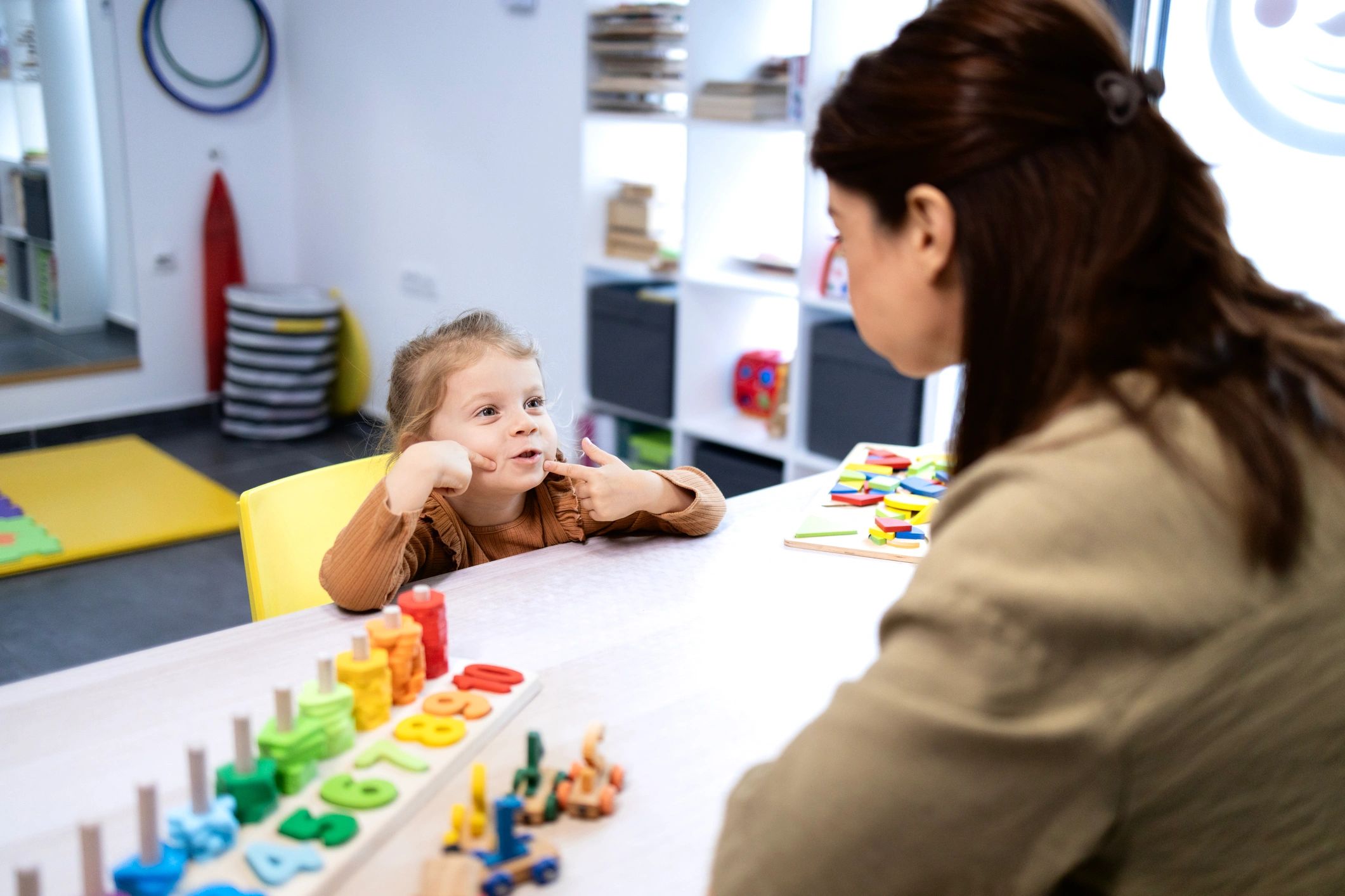 Child practicing speech therapy exercises with a therapist
