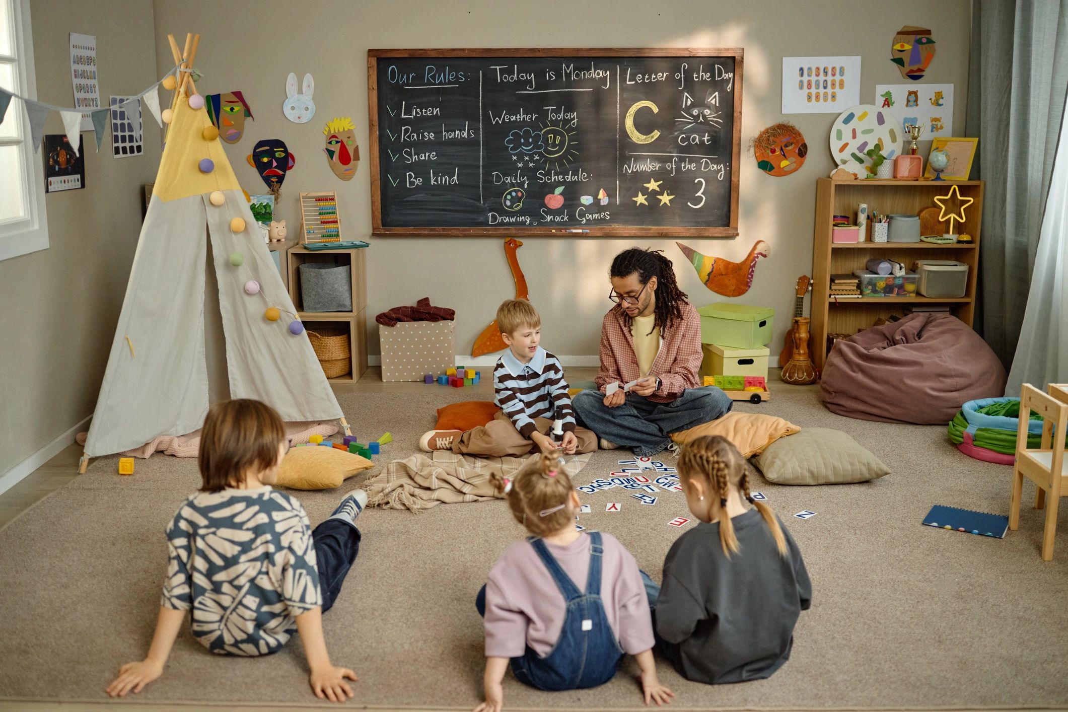 Children engaged in a classroom floor activity with a teacher